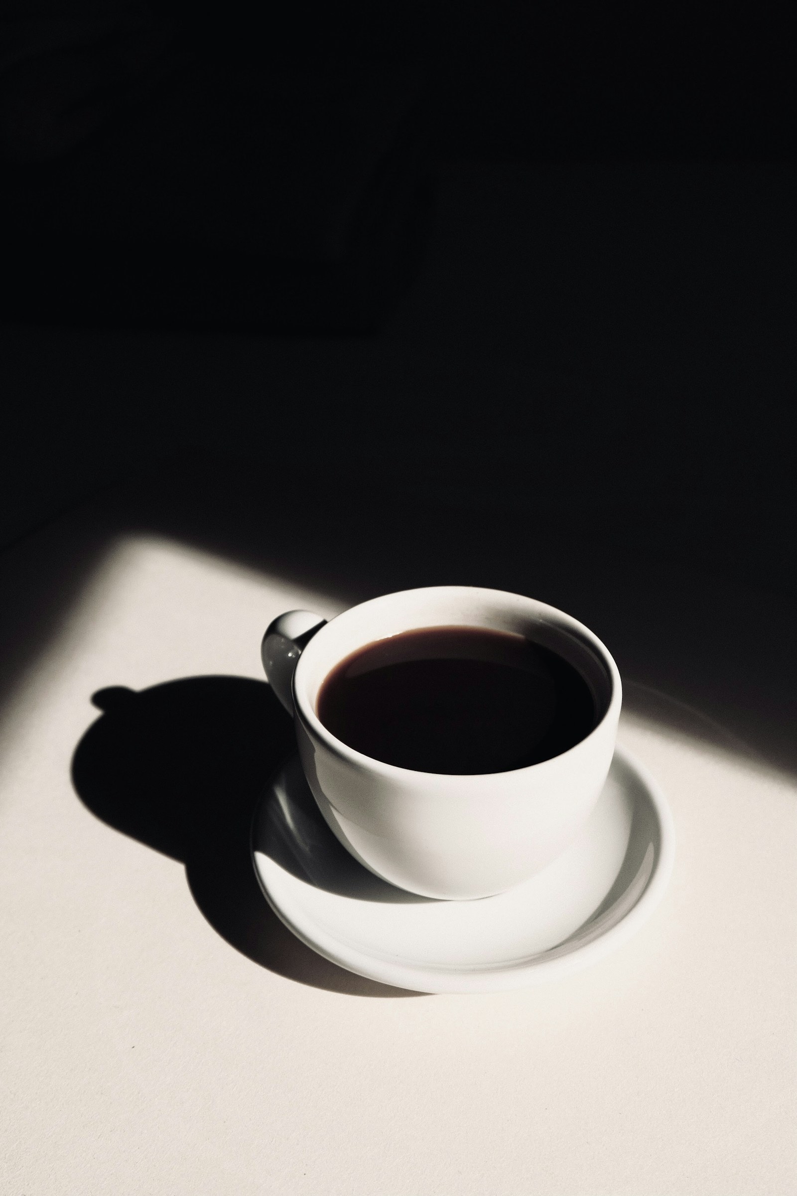 黒い背景に白いカップを置いた静物写真